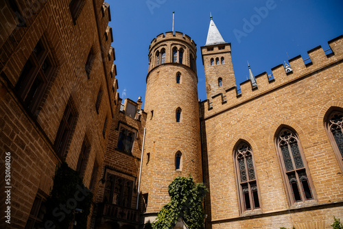 Burg Hohenzollern, Baden-Wurttemberg, Germany, 5 July 2022: medieval knights castle with towers in English Gothic Revival architecture, monument to Romanticism, old fortifications on hill at sunny day