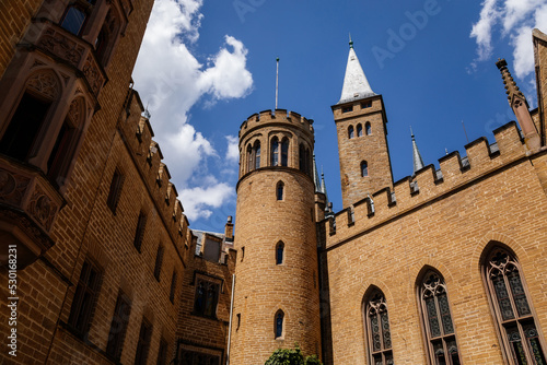 Burg Hohenzollern, Baden-Wurttemberg, Germany, 5 July 2022: medieval knights castle with towers in English Gothic Revival architecture, monument to Romanticism, old fortifications on hill at sunny day