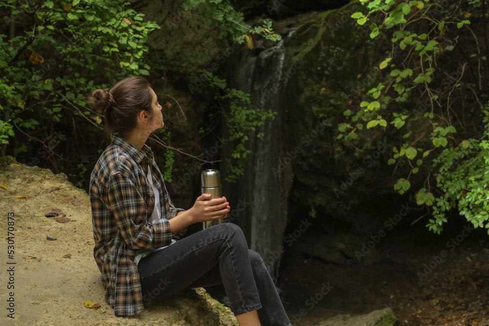 Fototapeta premium girl in the forest with a thermos