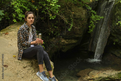 girl in the forest with a thermos