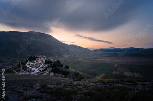 l'alba su castelluccio di norcia, ancora visibilmente ferito dal terremoto del centro italia del 2016, il sole sorge dietro al monte redentore, che sovrasta pian grande di castelluccio photo