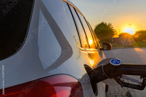 Car at hydrogen gas station. Fuel cell hydrogen car at hydrogen gas station is being fueled.hydrogen logo on gas stations fuel dispenser. h2 combustion engine for emission free eco friendly transport.