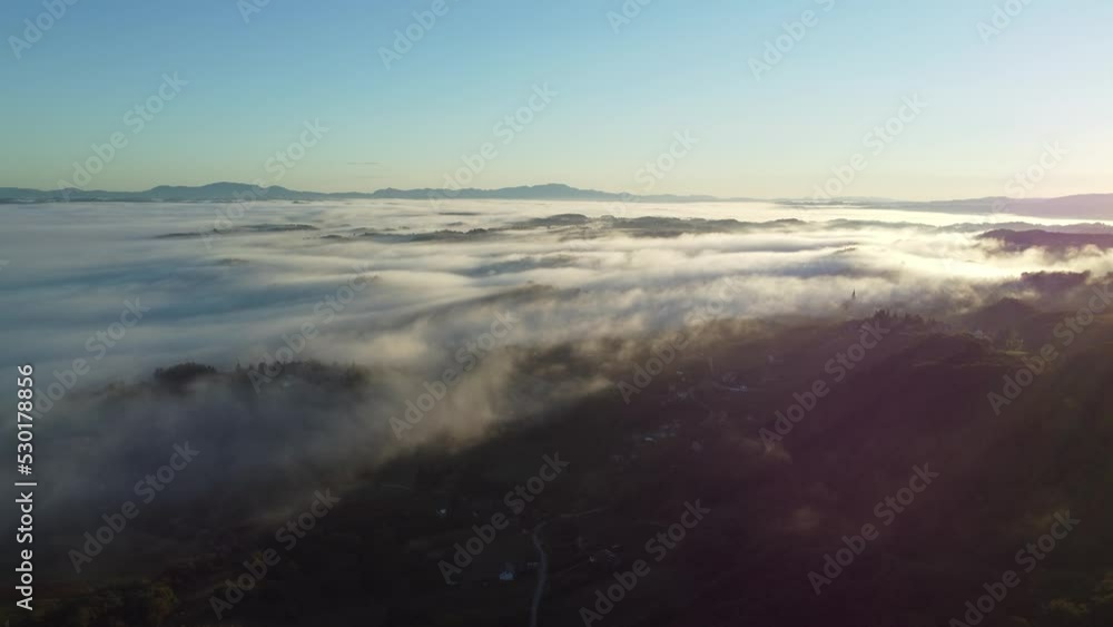 morning clouds move in a hilly area just before and at sunrise, central europe, shot by drone above the clouds at approximately 450 meters, late summer morning clouds move in a hilly area just before and at sunrise, central europe, shot by drone above the clouds at approximately 450 meters, late summer
