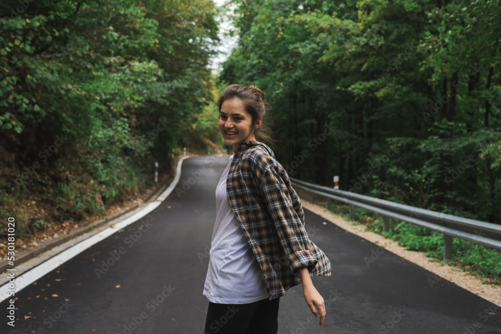 beautiful girl walks in the forest near the road beautiful girl walks in the forest near the road