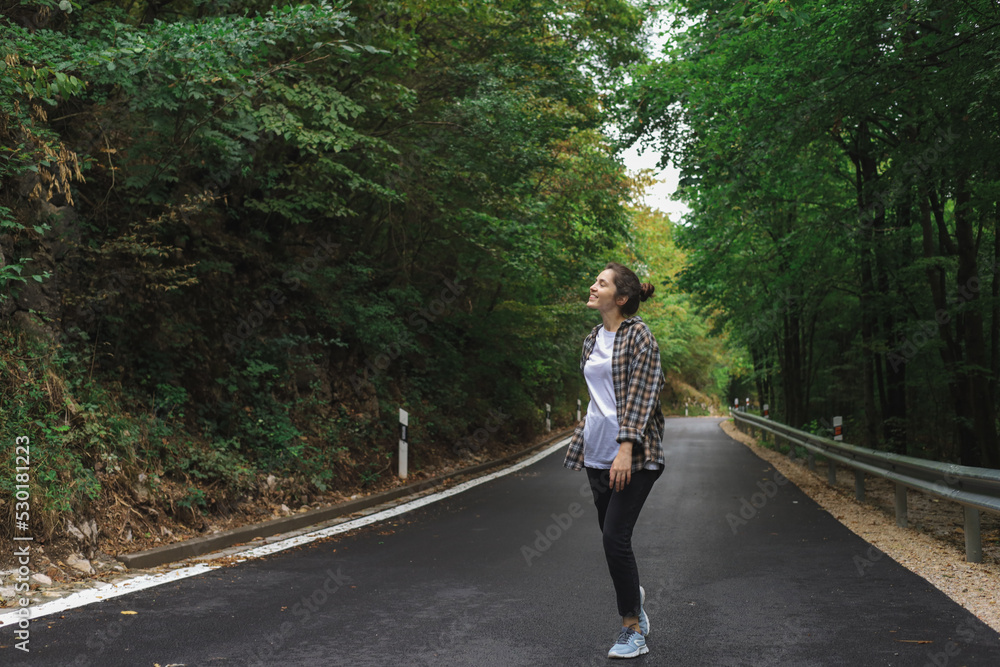 beautiful girl walks in the forest near the road beautiful girl walks in the forest near the road