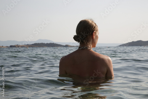 Back view of woman in the sea water. 