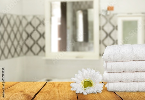 Fresh clean towels on wooden table in bathroom.