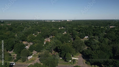 Drone flying around suburb neighborhoods with city skyscrapers in the background.