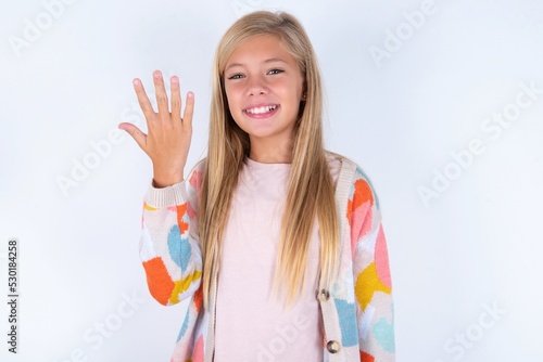 little kid girl wearing colorful yarn jacket over white background smiling and looking friendly  showing number five or fifth with hand forward  counting down