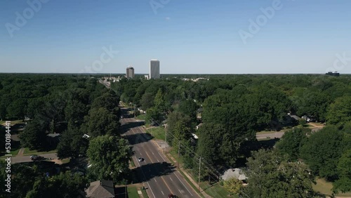 Drone flying around suburb neighborhoods with city skyscrapers in the background.
