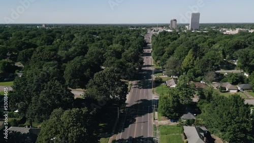 Drone flying around suburb neighborhoods with city skyscrapers in the background.