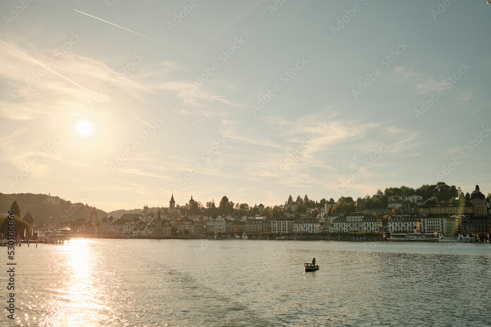 Fototapeta premium Sunlit lake with boat at sundown