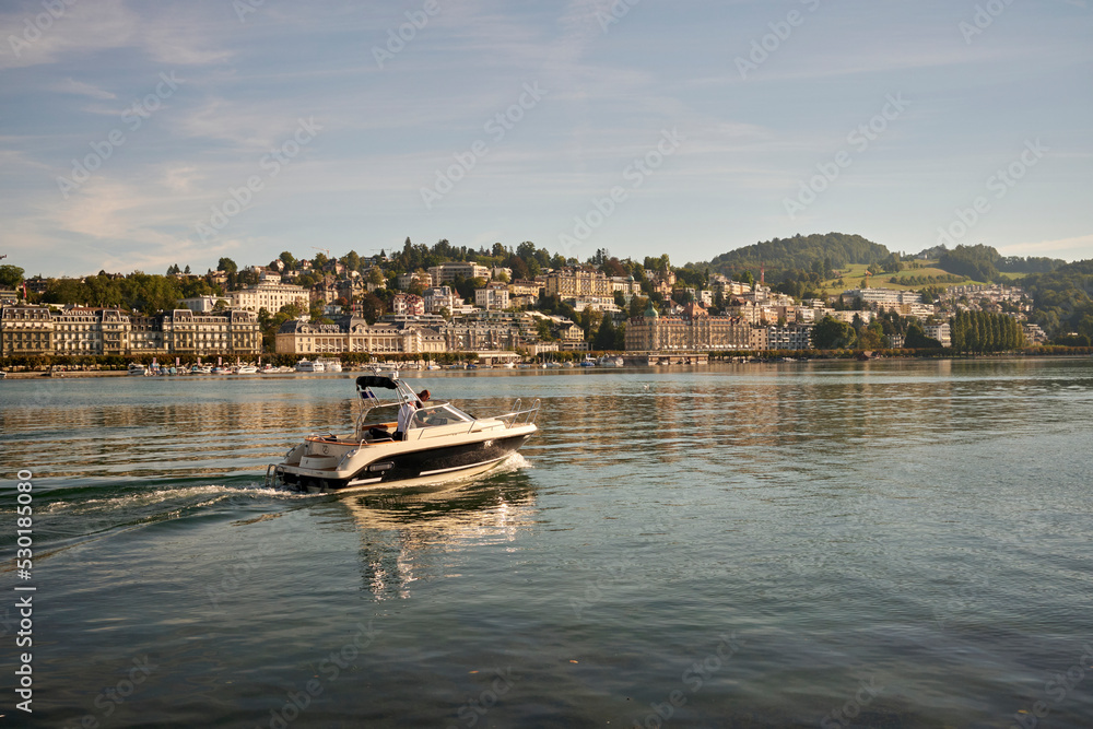 Motor boat floating in river at sunset in Switzerland