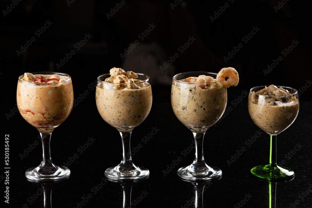Ceviche peruano, vegetariano y de camarones servidos en copas con un fondo negro Ceviche peruano, vegetariano y de camarones servidos en copas con un fondo negro