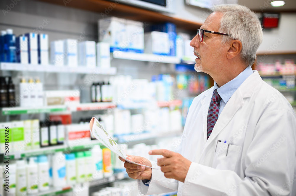 Senior pharmacist searching for a product on a shelf