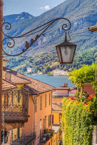 Fototapeta Naklejka Na Ścianę i Meble -  Colorful old town street with springtime balcony in Bellagio, Italy