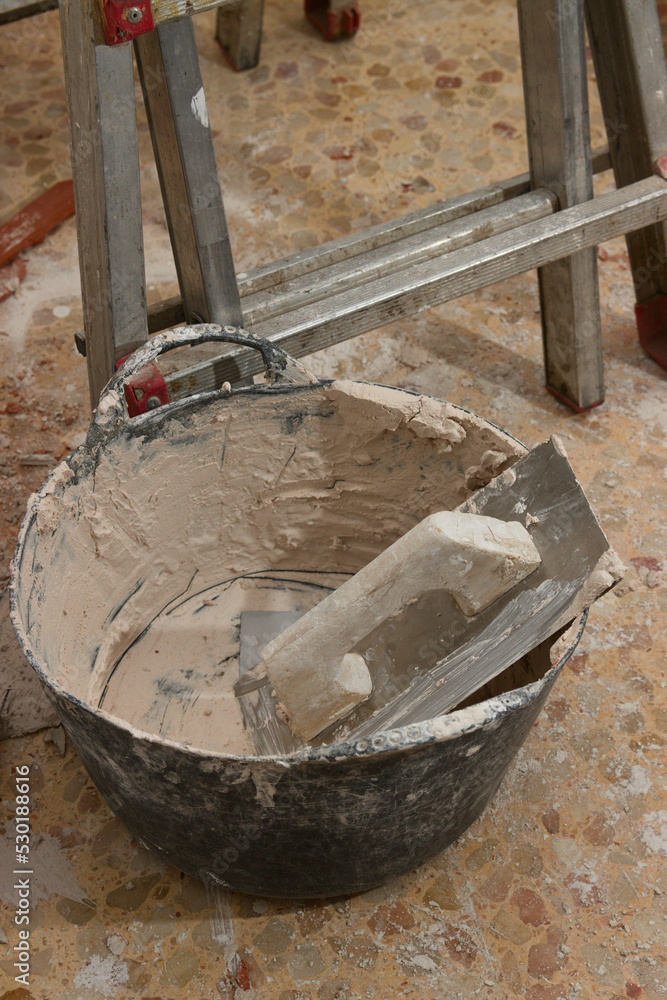 A trowel, a carrycot with plaster and a ladder, tools of a mason reforming interiors, A trowel, a carrycot with plaster and a ladder, tools of a mason reforming interiors,