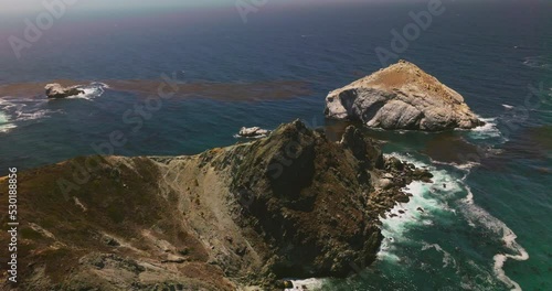 Bare sandrocks washed by the foamy waves. Beautiful sunny day at the rocky shore of California, USA. Top view. photo