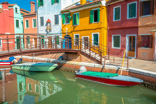 Burano island canal reflection, colorful houses and boats, Venetian lagoon © Aide