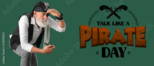 Mature pirate with smoking pipe on green background. Talk Like a Pirate Day photo