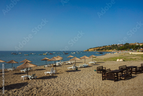 clean beach in istanbul city. sandy beach with wooden umbrellas in turkey. private club promenade for villa residents