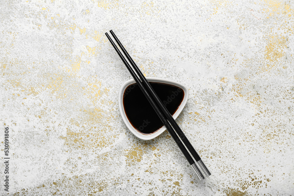 Bowl of soy sauce and chopsticks on grunge background Bowl of soy sauce and chopsticks on grunge background