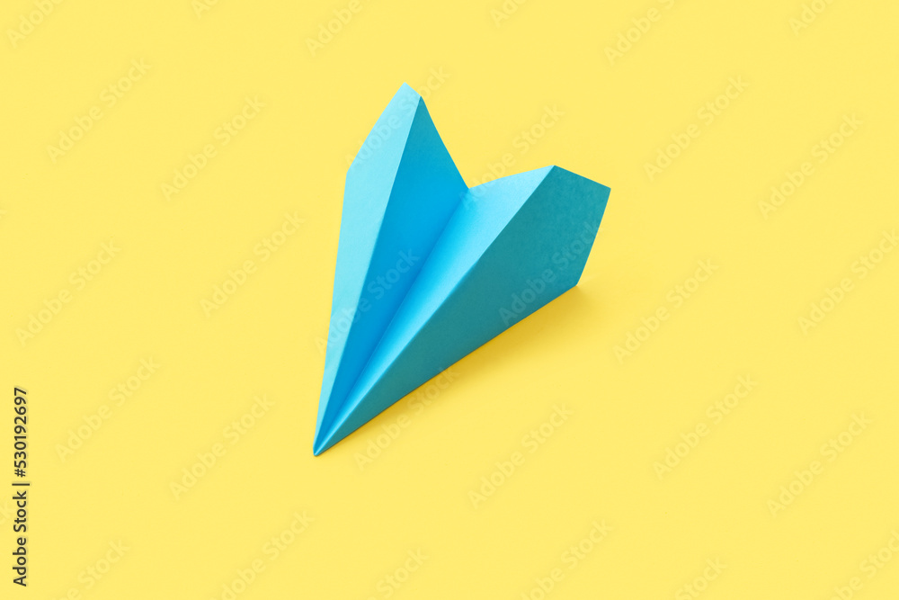 Blue paper plane on yellow background Blue paper plane on yellow background