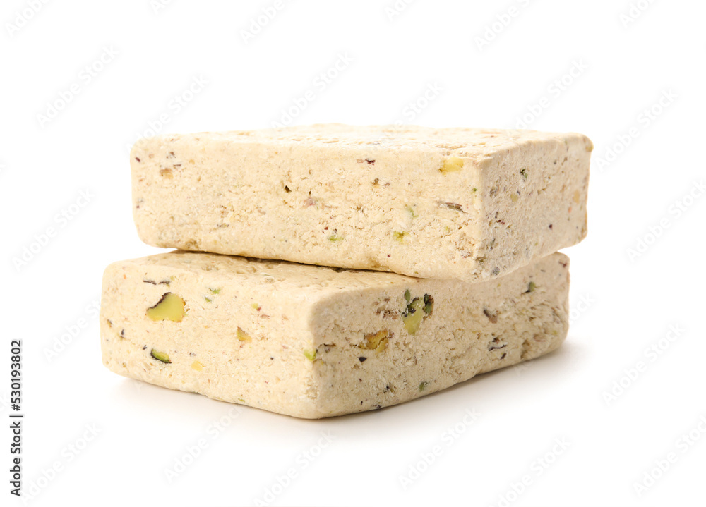 Pieces of delicious sesame halva on white background