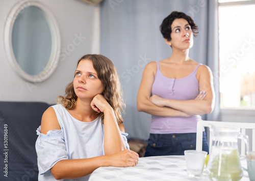 Angry irritated young adult woman don't speaking after discord with girlfriend at home