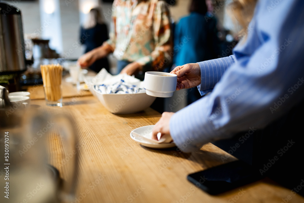 Coffee tasting, close-up of a girl's hands with a cup of coffee on the background of the table Coffee tasting, close-up of a girl's hands with a cup of coffee on the background of the table