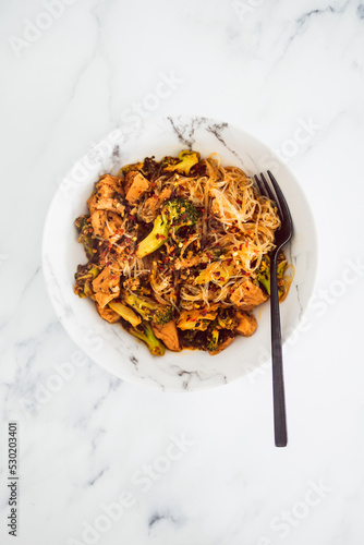 healthy vegan food, broccoli and plant-based chicken stiry fry with vermicelli noodles photo