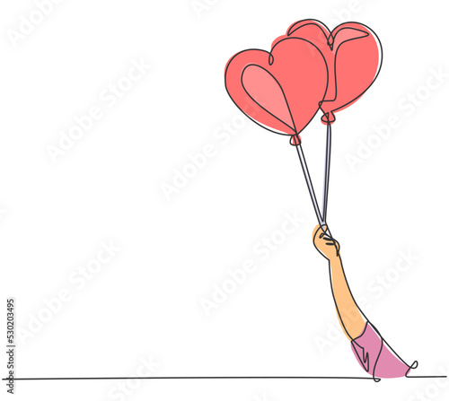 One continuous line drawing of young happy girl holding a couple cute heart shaped balloon tightly. Romantic wedding invitation card concept. Modern single line draw design graphic vector illustration