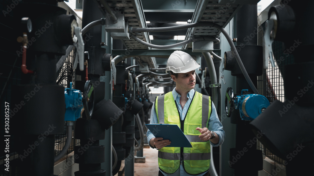 Engineers are inspecting a large building or industrial facility's cooling system for the air conditioning. Engineers are inspecting a large building or industrial facility's cooling system for the air conditioning.