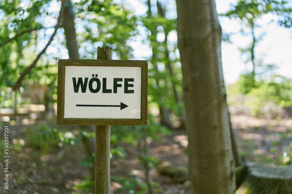 Schild mit Richtungspfeil zu einem Gehege mit Wölfen in Deutschland 