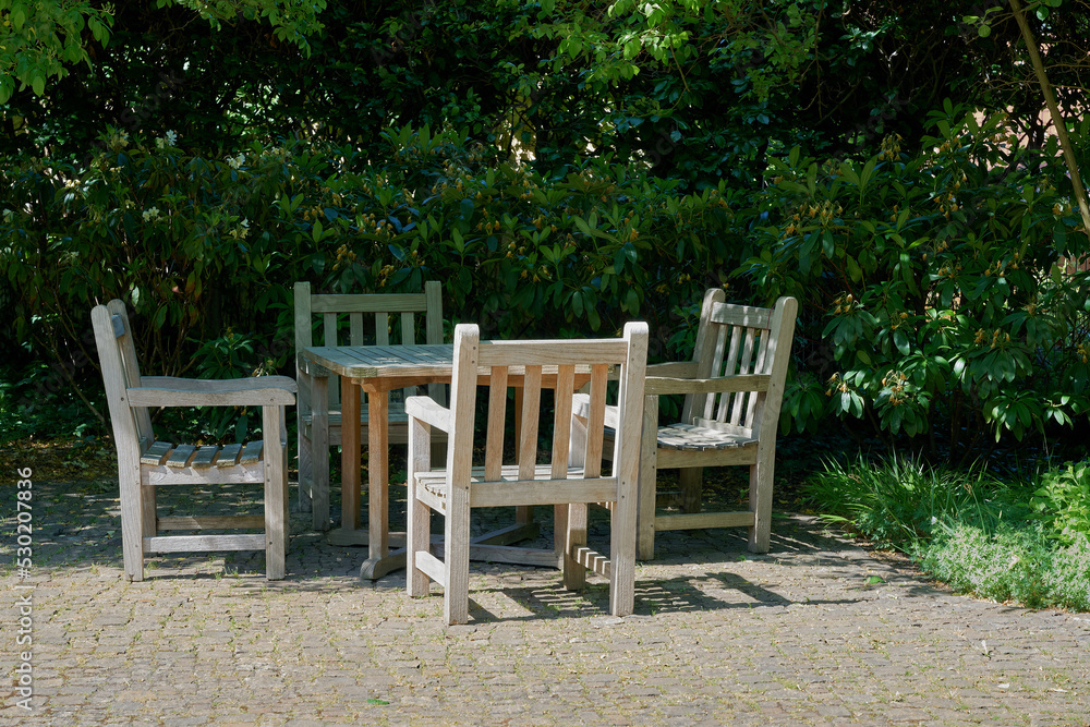 Stühle und Tisch zum Ausruhen in einer gemütlichen Ecke im Garten Stühle und Tisch zum Ausruhen in einer gemütlichen Ecke im Garten
