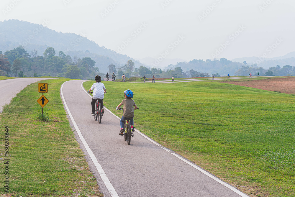 Obraz premium People are doing exercises on bicycles on the streets in the park.