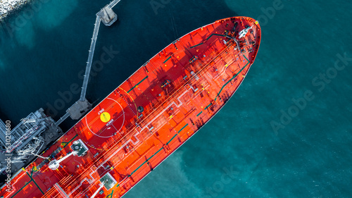 Aerial view oil ship tanker vessel loading and unloading in oil terminal station refinery, Global business import export logistic transport sea freight cargo tanker, Red crude oil tanker ship at port.