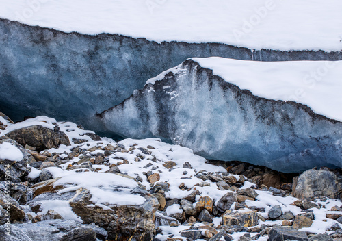 Glacier high in the mountains. A high layer of ice permafrost on a mountain peak. photo
