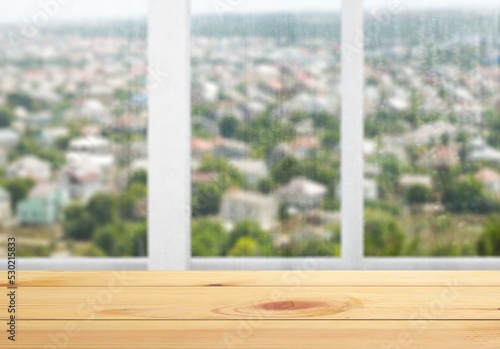 Wood  table with window glass and city background. © BillionPhotos.com