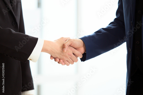 unrecognizable businesspeople doing a handshake together after done and completed business negotiation. © DG PhotoStock