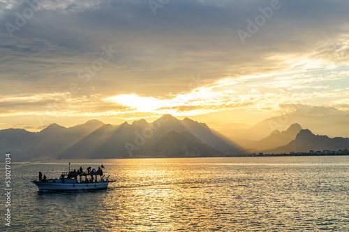 Kleines Boot beim Einlaufen in den Hafen von Antalya im abendlichen Gegenlicht