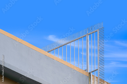 Low angle view of metal spike fence on rooftop of tenement building for security concept