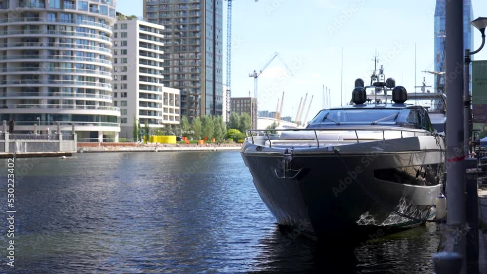 Large luxury boat is docked on the side of the canal in Canary Wharf ...
