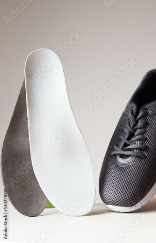 Gray sport shoes  with orthopedic insoles. Foot care products conception.