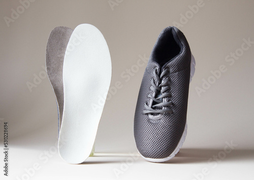 Gray sport shoes  with orthopedic insoles. Foot care products conception.