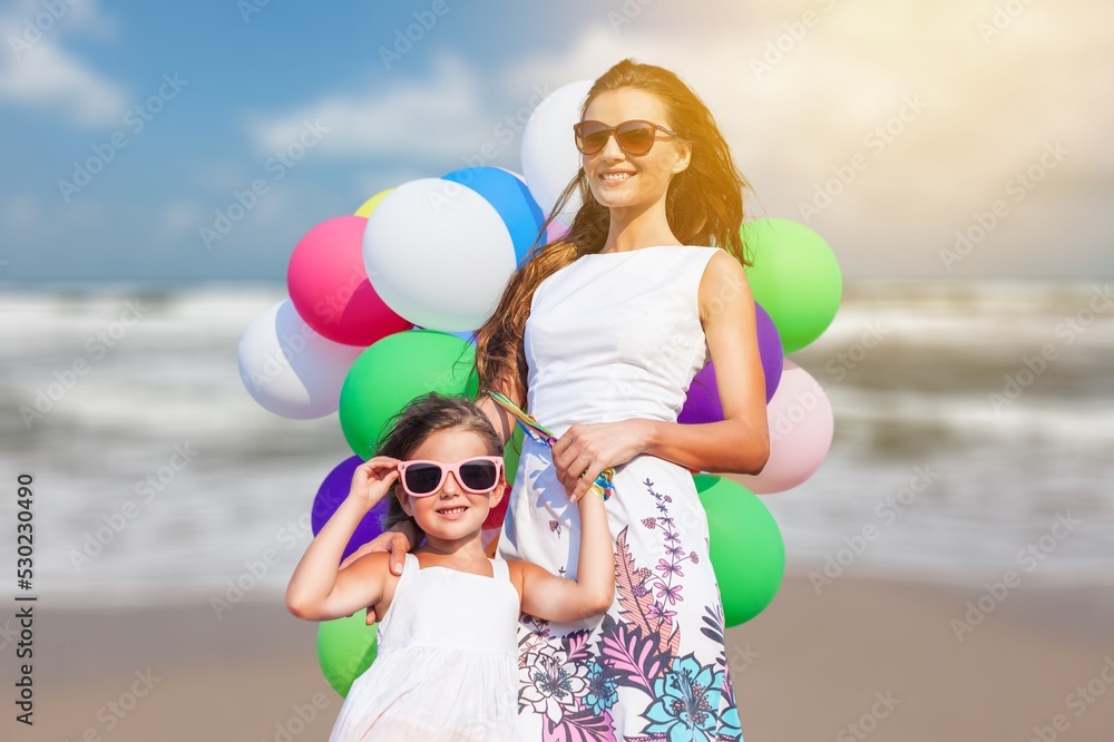 Happy family on beach. Mother and little daughter playing together Happy family on beach. Mother and little daughter playing together