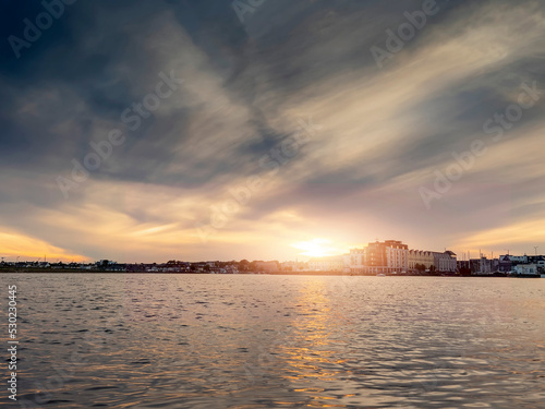 Stunning sunset over Galway city, Ireland. Beautiful dramatic sky over The Long Walk area by the Docks. Warm and cool tone. Popular town on West coast.
