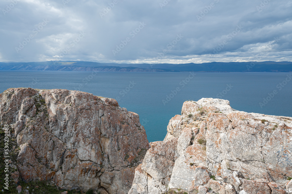 Beautiful summer landscape of Baikal Lake on sunny day. View of the rocky cape Beautiful summer landscape of Baikal Lake on sunny day. View of the rocky cape