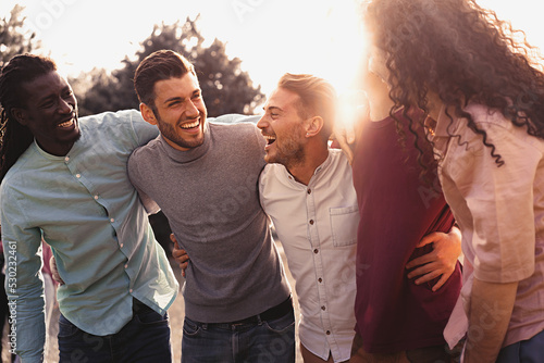 Obraz na plátně multi-ethnic group of positive friends hugging and having fun outdoors