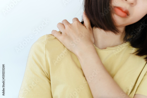 Woman's hand massaging the shoulder blades due to pain from sitting for a long time Cause of office syndrome.